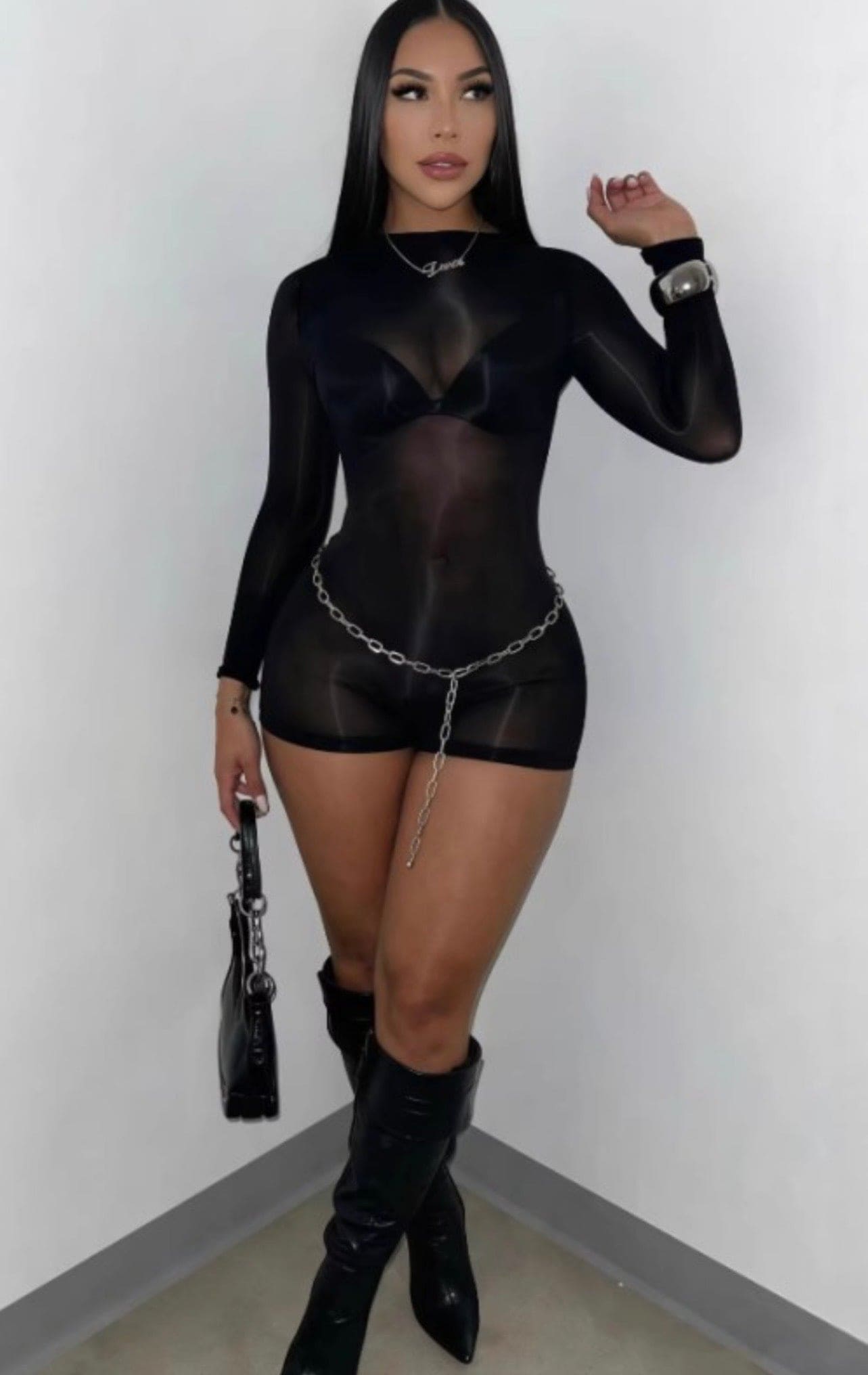 Black sheer glossy romper from Sugarz Chique Boutique featuring a fitted design and lightweight, see-through fabric.
