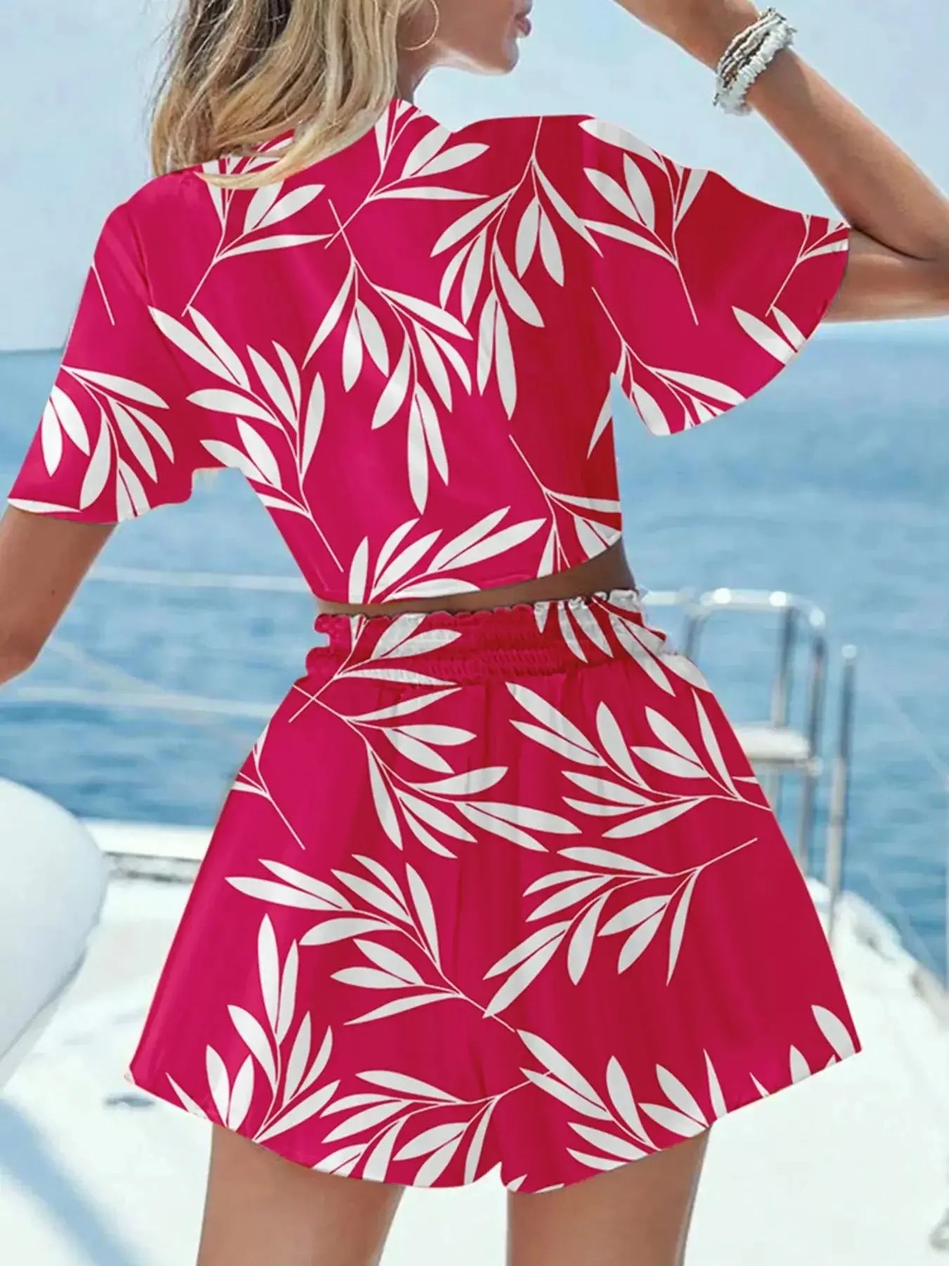 Women's printed tie front top and shorts set in vibrant pink with white leaf patterns, perfect for summer outings.
