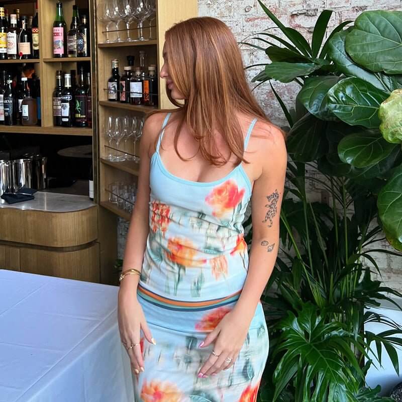 Woman wearing cute printed contrast color slim fit sling sheath skirt outfit amidst greenery and bar background.