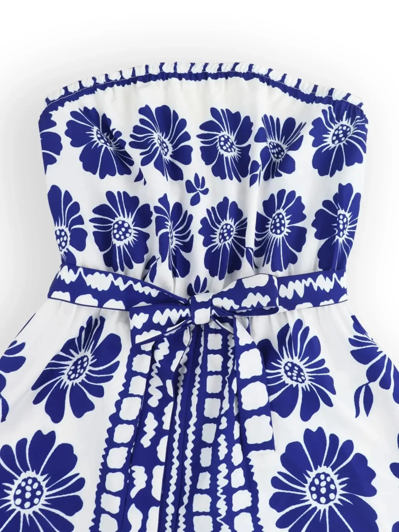 Printed tube tie waist romper featuring vibrant blue floral pattern and belted waist design.