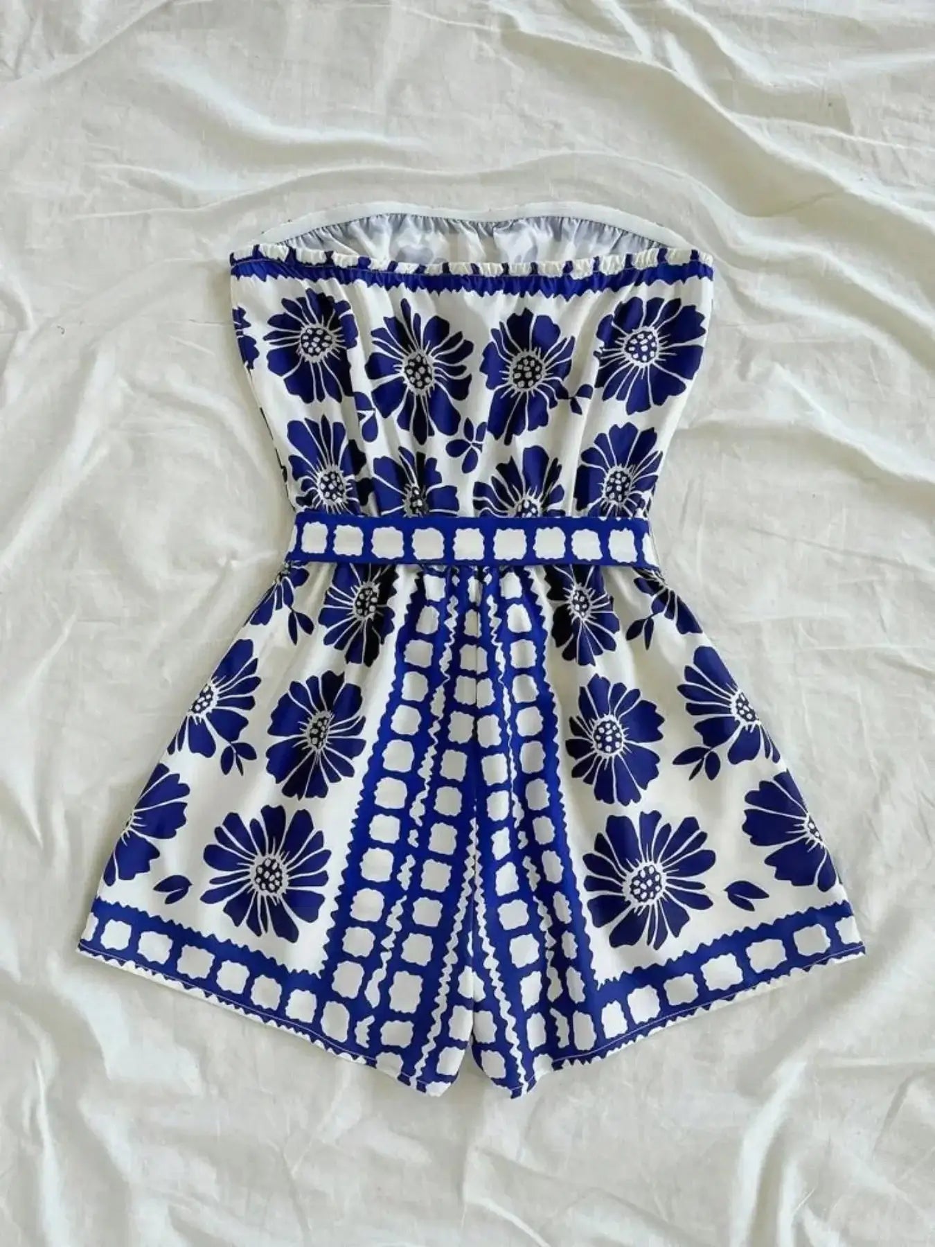 Printed tube tie waist romper in floral design, featuring a belted waist and comfortable polyester material.