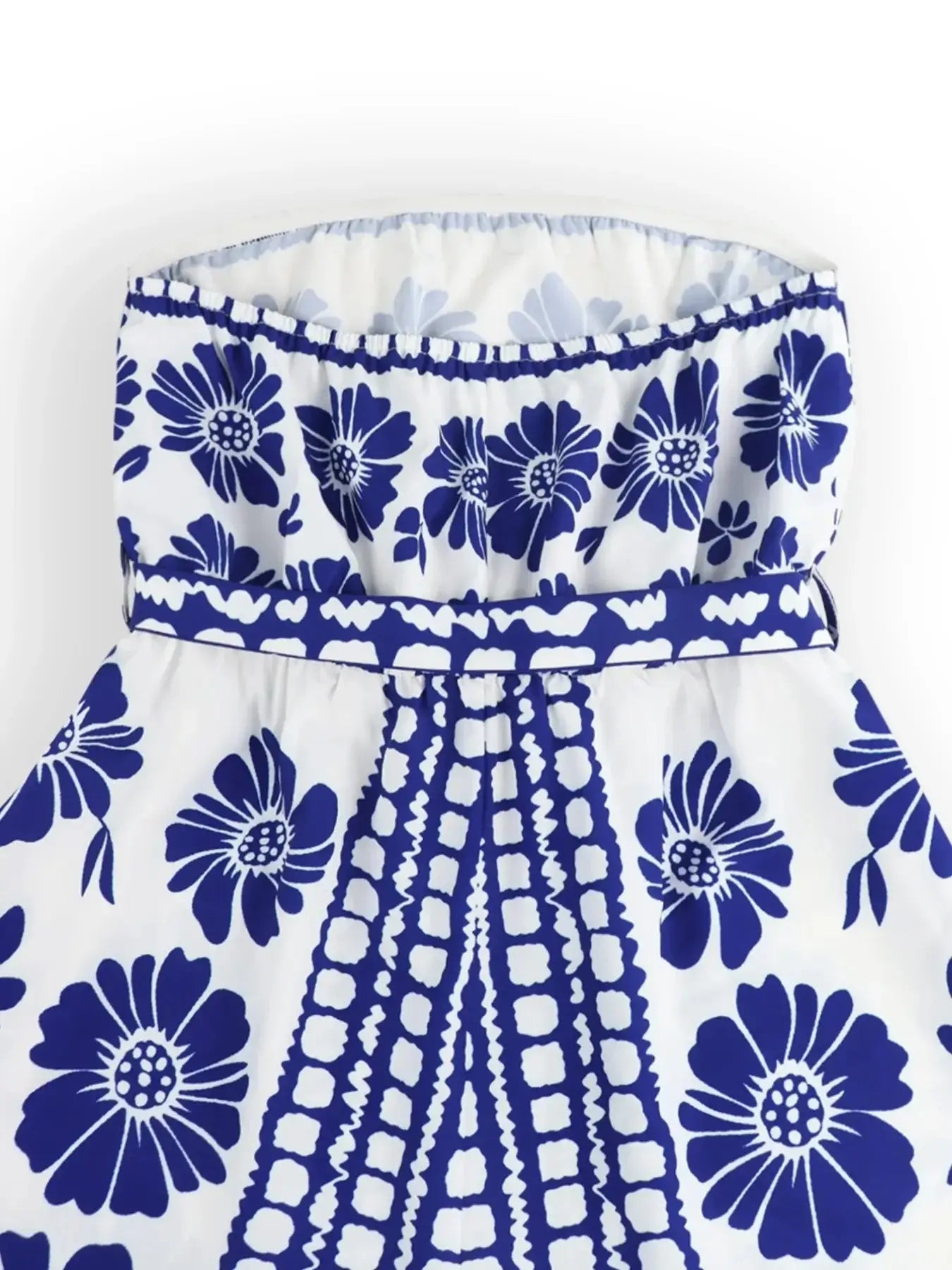 Close-up of printed tube tie waist romper featuring vibrant blue floral design and belted waist detail.