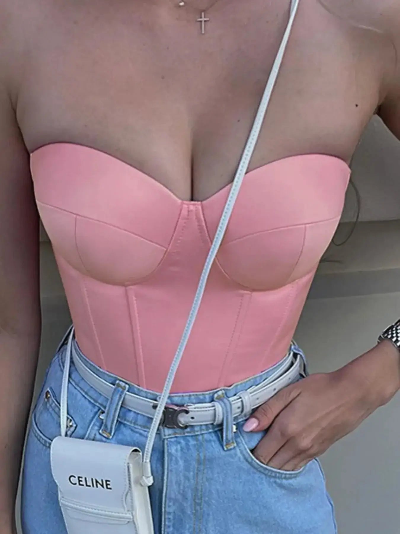 Model wearing a pink sweetheart neck tube top with a stylish high-waisted denim look, showcasing its flattering design.