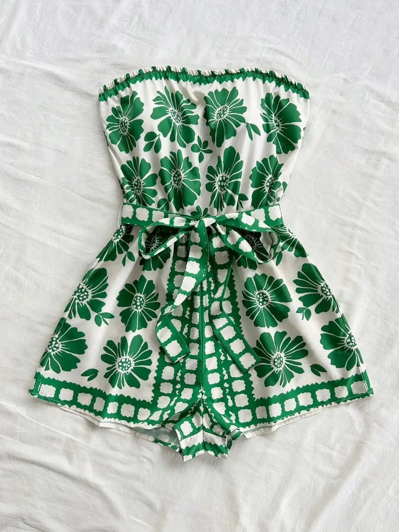 Printed tube tie waist romper in green floral pattern, belted design, 100% polyester fabric.