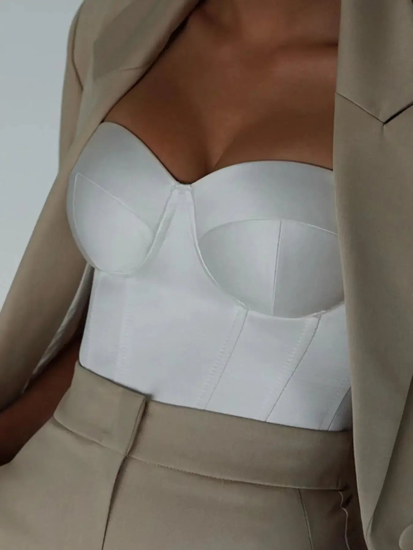 Elegant sweetheart neck tube top in white, featuring structured design and paired with a stylish beige blazer.