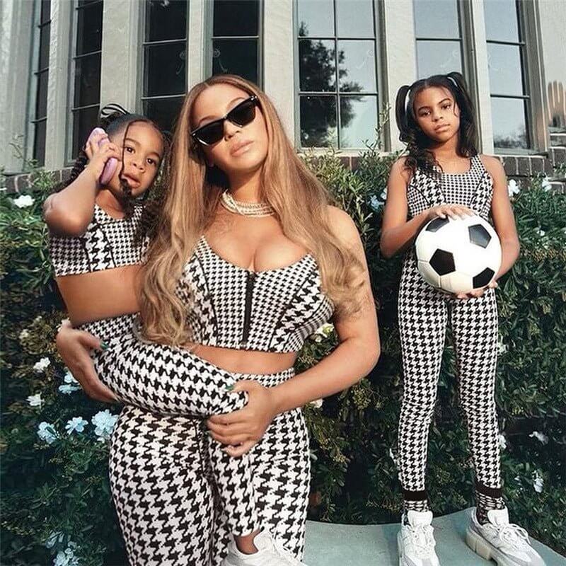 Family in matching houndstooth patterned outfits enjoying outdoor fun, featuring a mom and her two daughters.